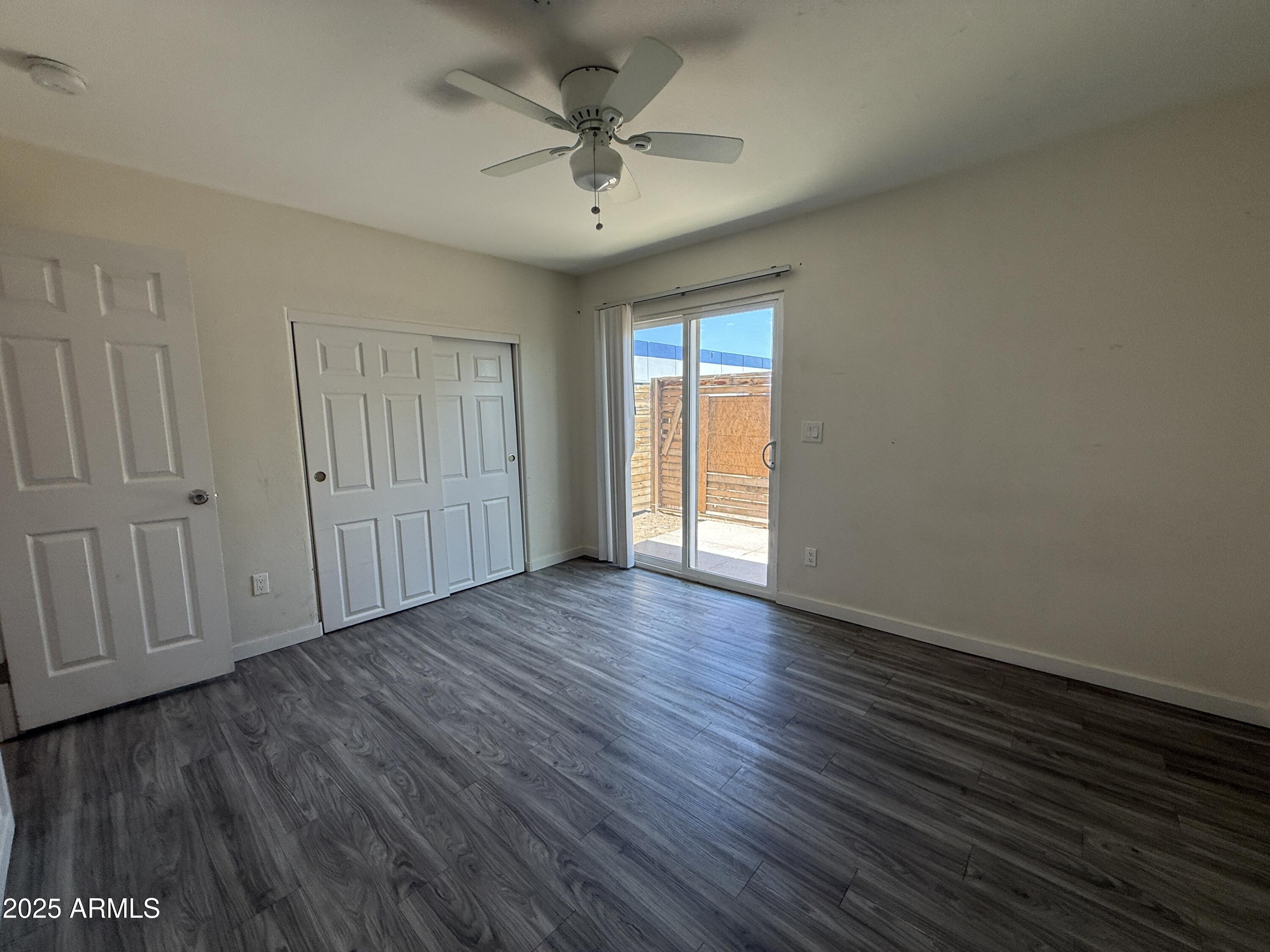 1625 West Fillmore Street, Unit 1 Phoenix, AZ 85007 - Photo 8 of 10 a view of an empty room with wooden floor and a ceiling fan