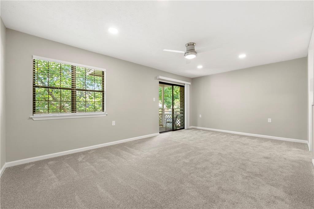 475 Mount Vernon Highway Northeast, Unit 226C Atlanta, GA 30328 - Photo 2 of 24 an empty room with windows and ceiling fan