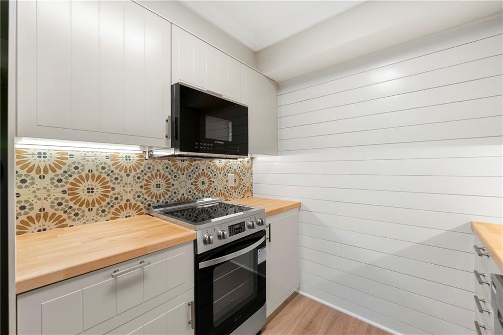 475 Mount Vernon Highway Northeast, Unit 226C Atlanta, GA 30328 - Photo 6 of 24 a kitchen with a stove and a microwave