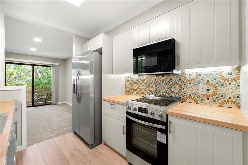 475 Mount Vernon Highway Northeast, Unit 226C Atlanta, GA 30328 - Photo 8 of 24 a kitchen with stainless steel appliances granite countertop a stove microwave and refrigerator