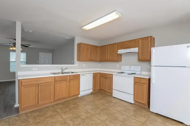 a kitchen with sink a refrigerator and cabinets