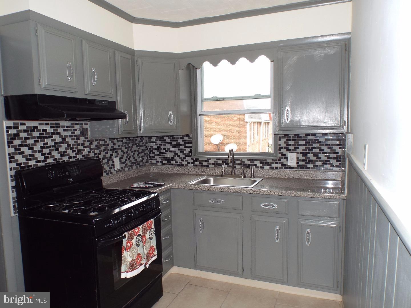 105 Ashton Road Upper Darby, PA 19082 - Photo 7 of 15 a kitchen with granite countertop a stove a sink and a microwave