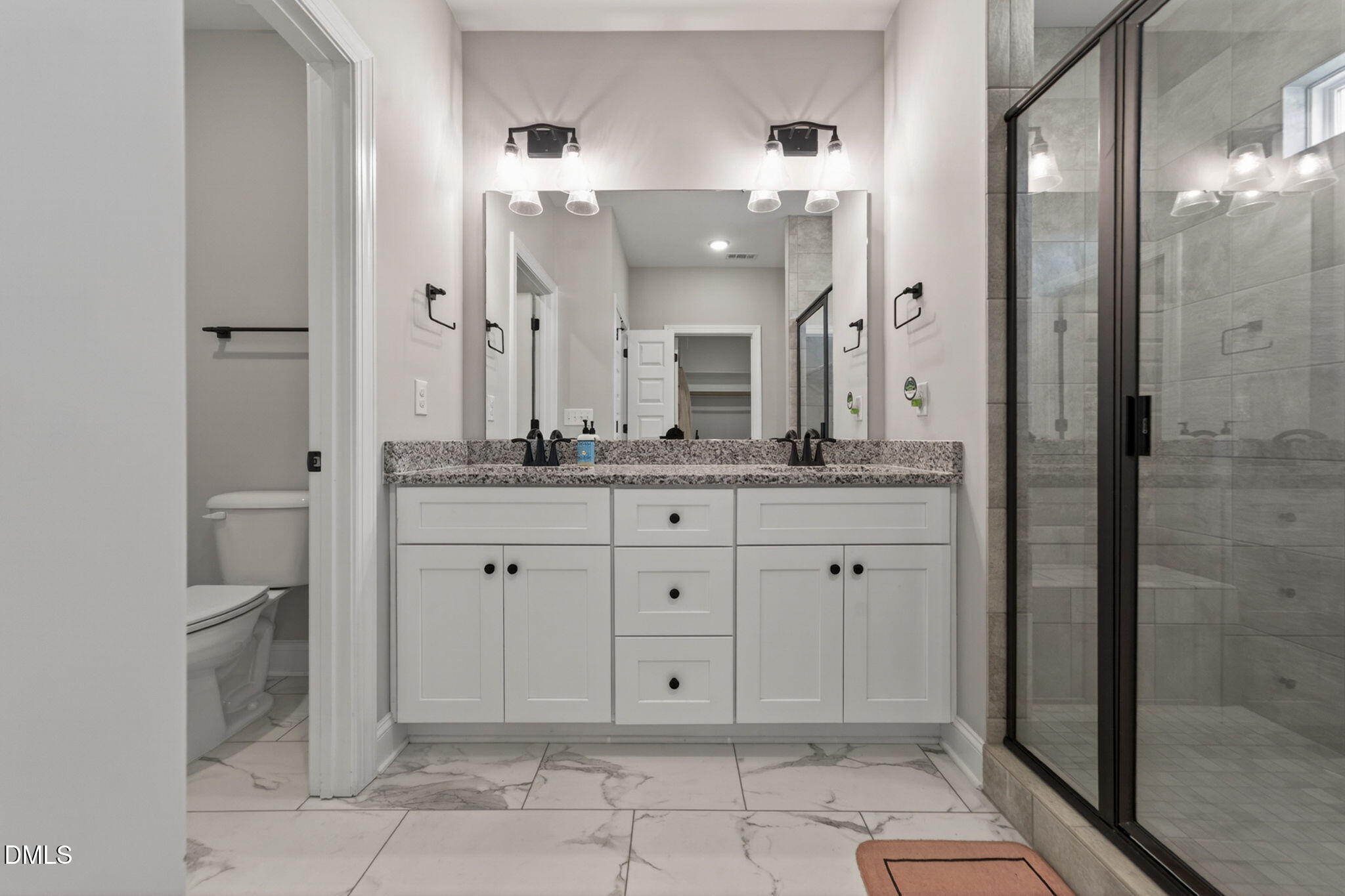 9205 Raccoon Drive Middlesex, NC 27557 - Photo 11 of 20 a spacious bathroom with a granite countertop sink mirror and shower