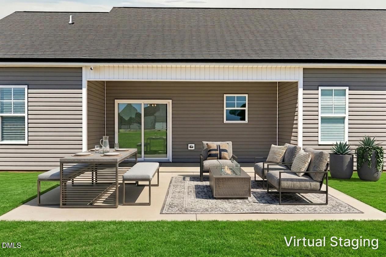 9205 Raccoon Drive Middlesex, NC 27557 - Photo 19 of 20 a view of a patio with table and chairs with a yard