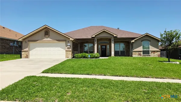 a front view of a house with a yard and garage