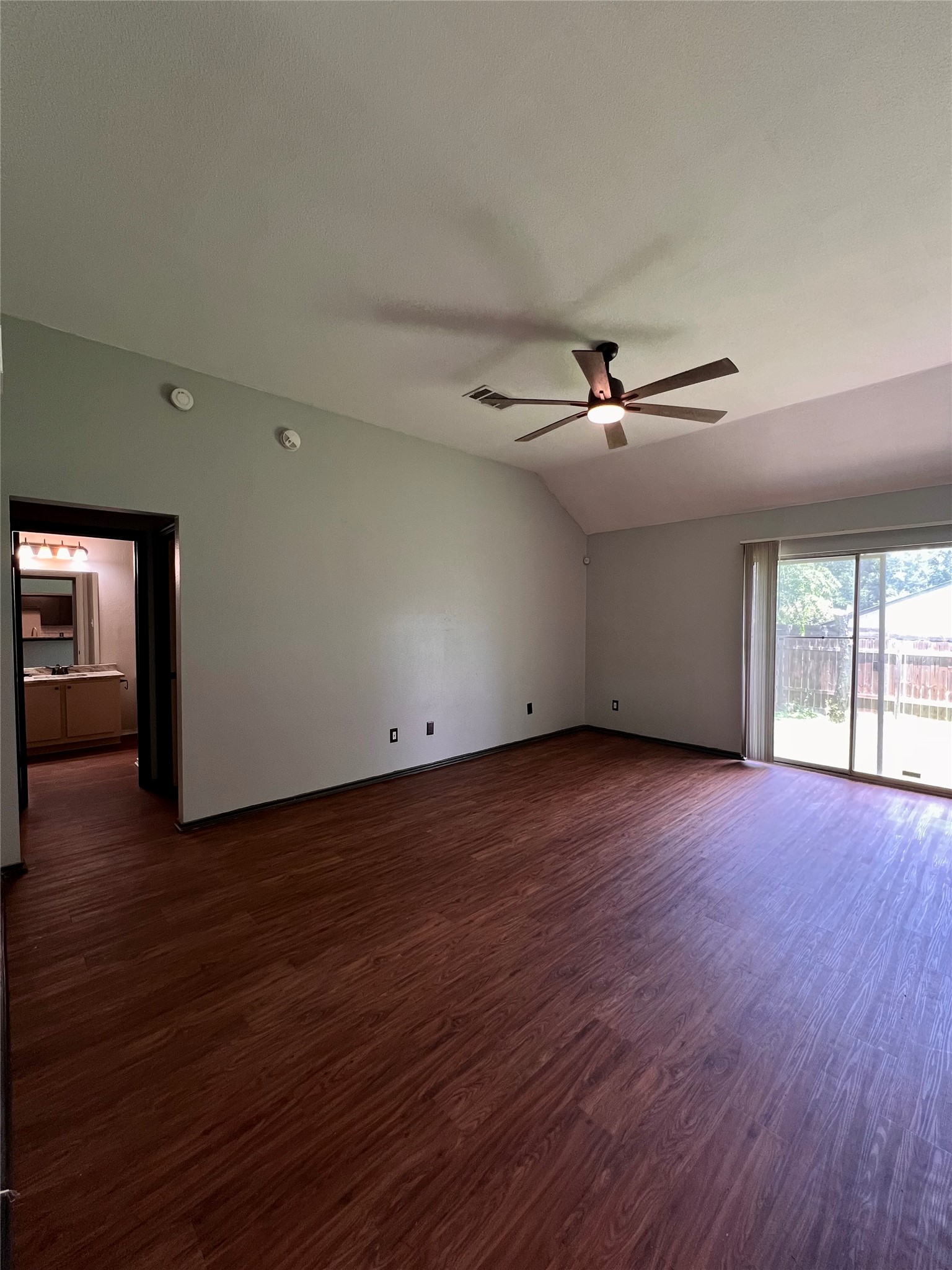 5404 China Berry Road Austin, TX 78744 - Photo 9 of 20 A generous interior space features vaulted ceilings, ample flooring, and direct outdoor access.