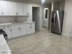 a kitchen with a refrigerator sink and cabinets