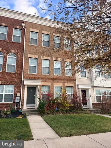 front view of a brick house with a yard