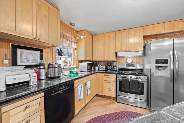 a kitchen with stainless steel appliances granite countertop a stove a sink and a refrigerator