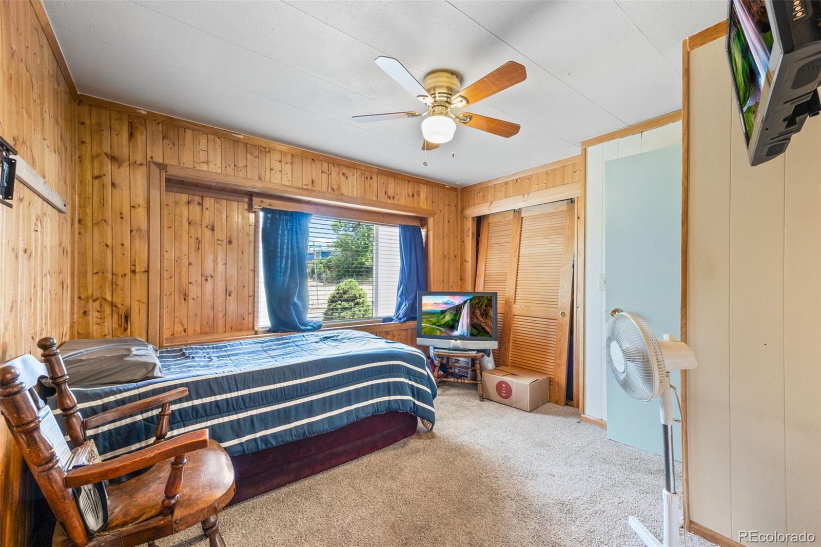 9129 Rampart Street Denver, CO 80260 - Photo 13 of 27 a bedroom with a bed and a chandelier