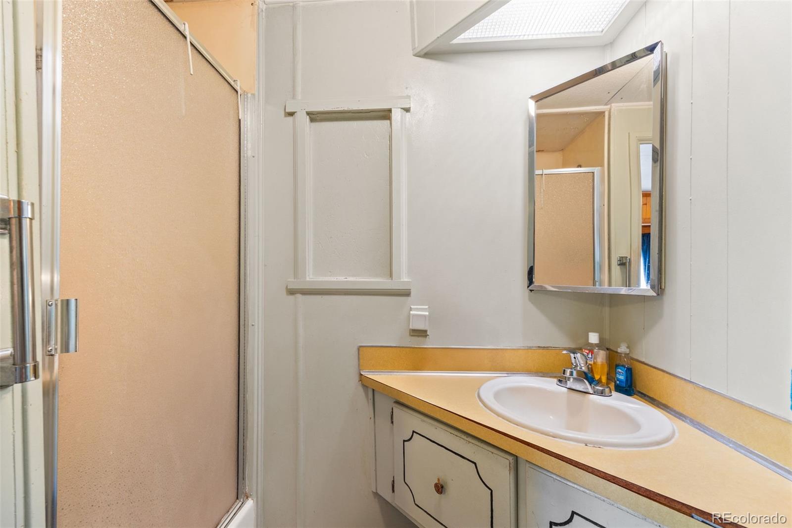 9129 Rampart Street Denver, CO 80260 - Photo 14 of 27 a bathroom with a sink and a mirror