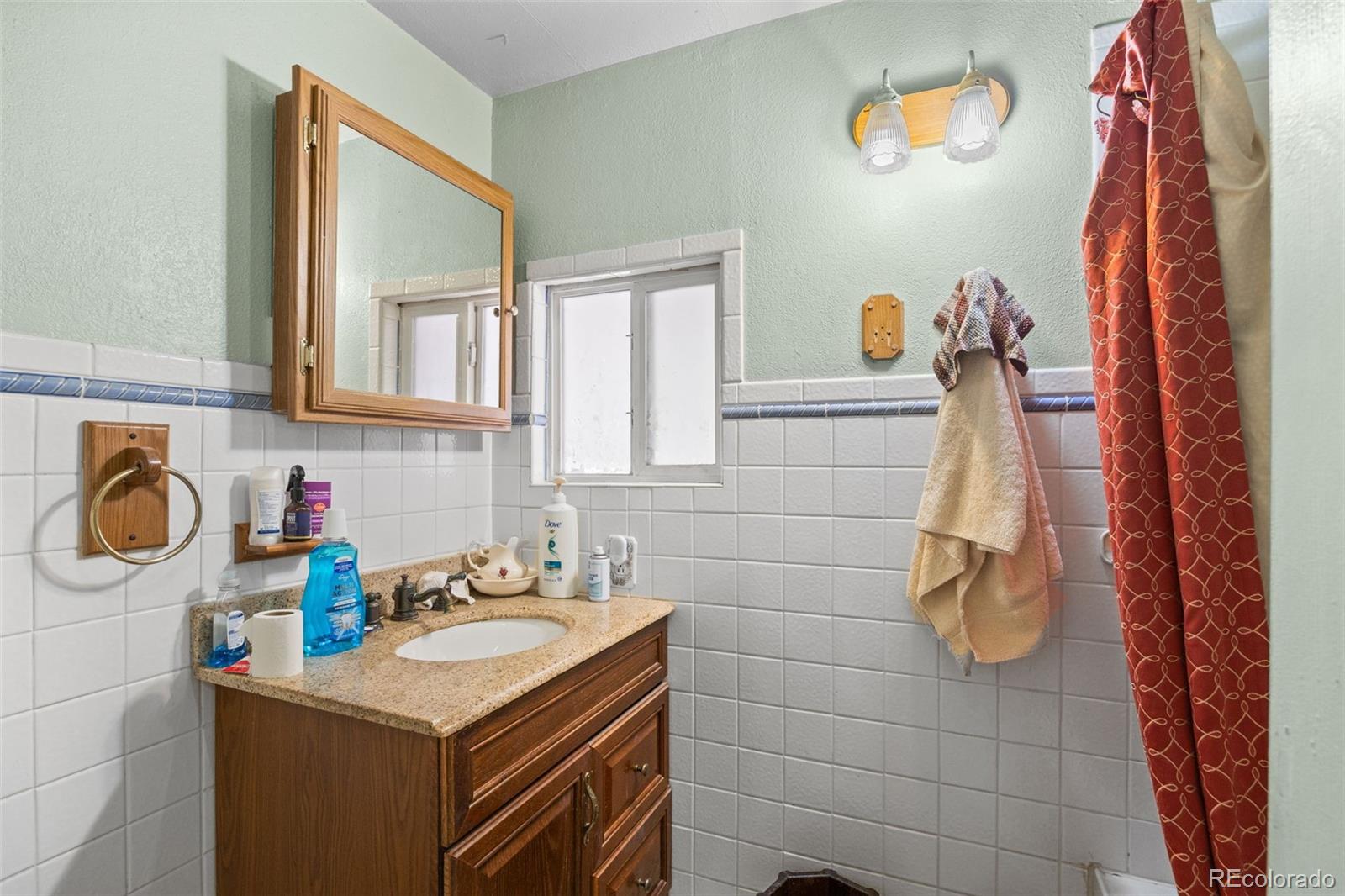 9129 Rampart Street Denver, CO 80260 - Photo 16 of 27 a bathroom with a sink and a mirror