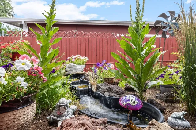 a view of a backyard with a table and chair with wooden floor and fence