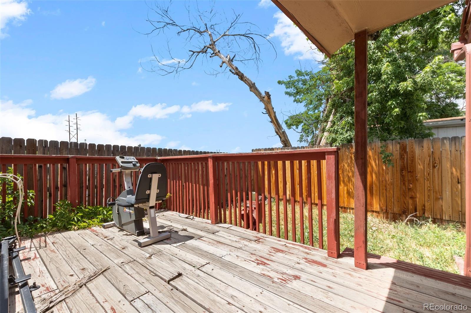 9129 Rampart Street Denver, CO 80260 - Photo 25 of 27 a view of a backyard with a table and chair with wooden floor and fence