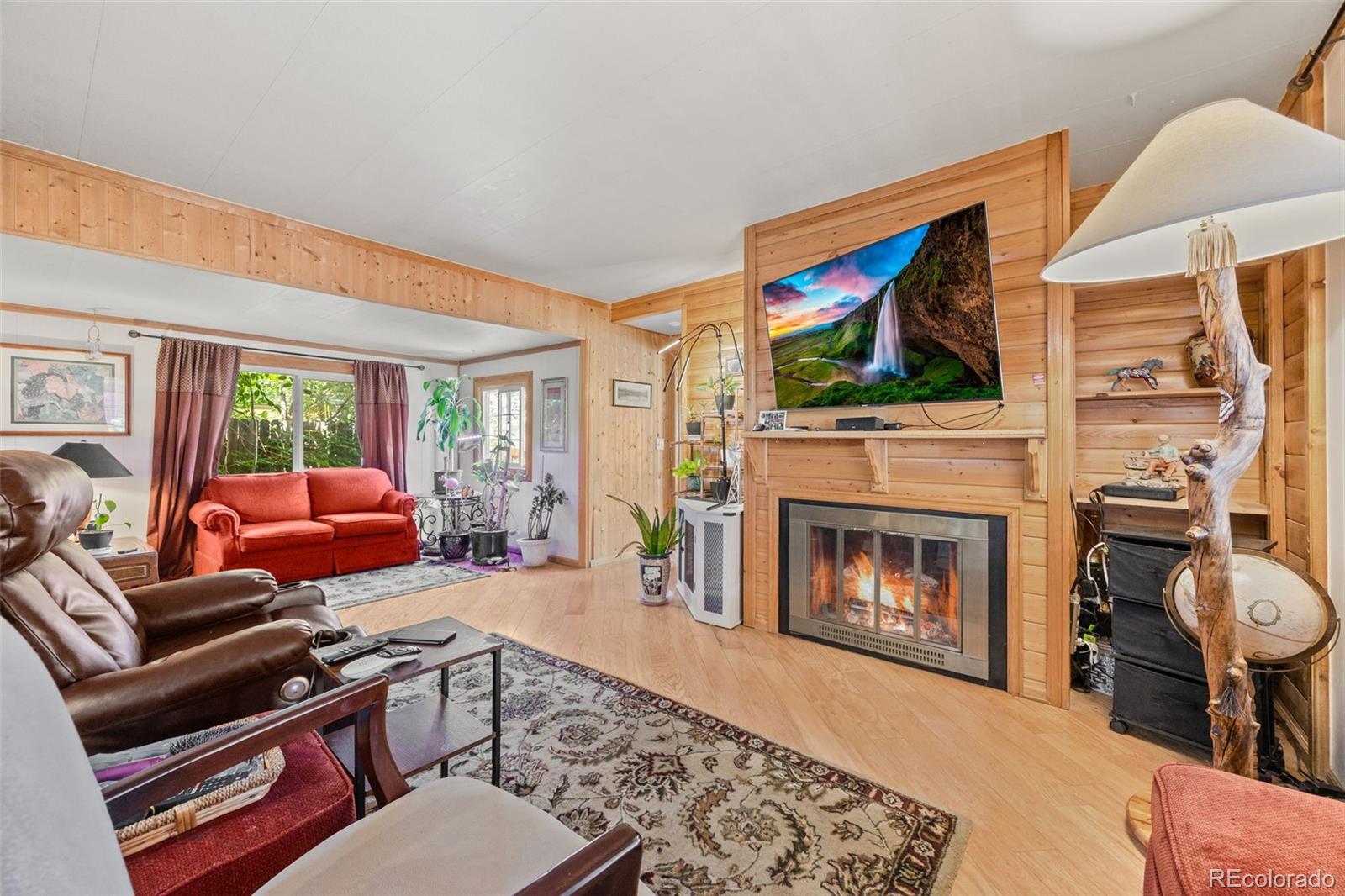 9129 Rampart Street Denver, CO 80260 - Photo 4 of 27 a living room with furniture a flat screen tv and a fireplace