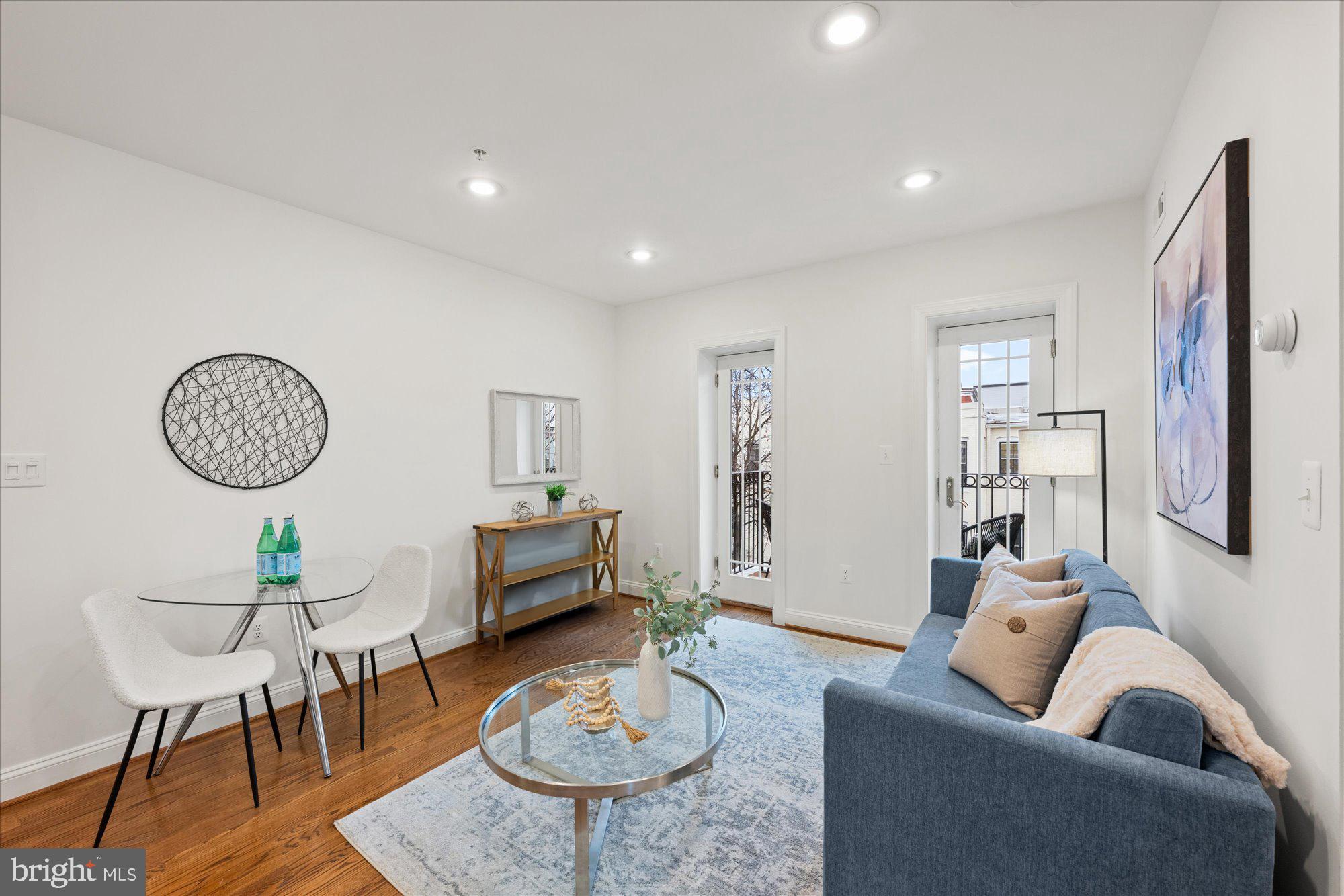 660 Morton Place Northeast, Unit 5 Washington, DC 20002 - Photo 5 of 21 a living room with furniture a dining table and a chandelier