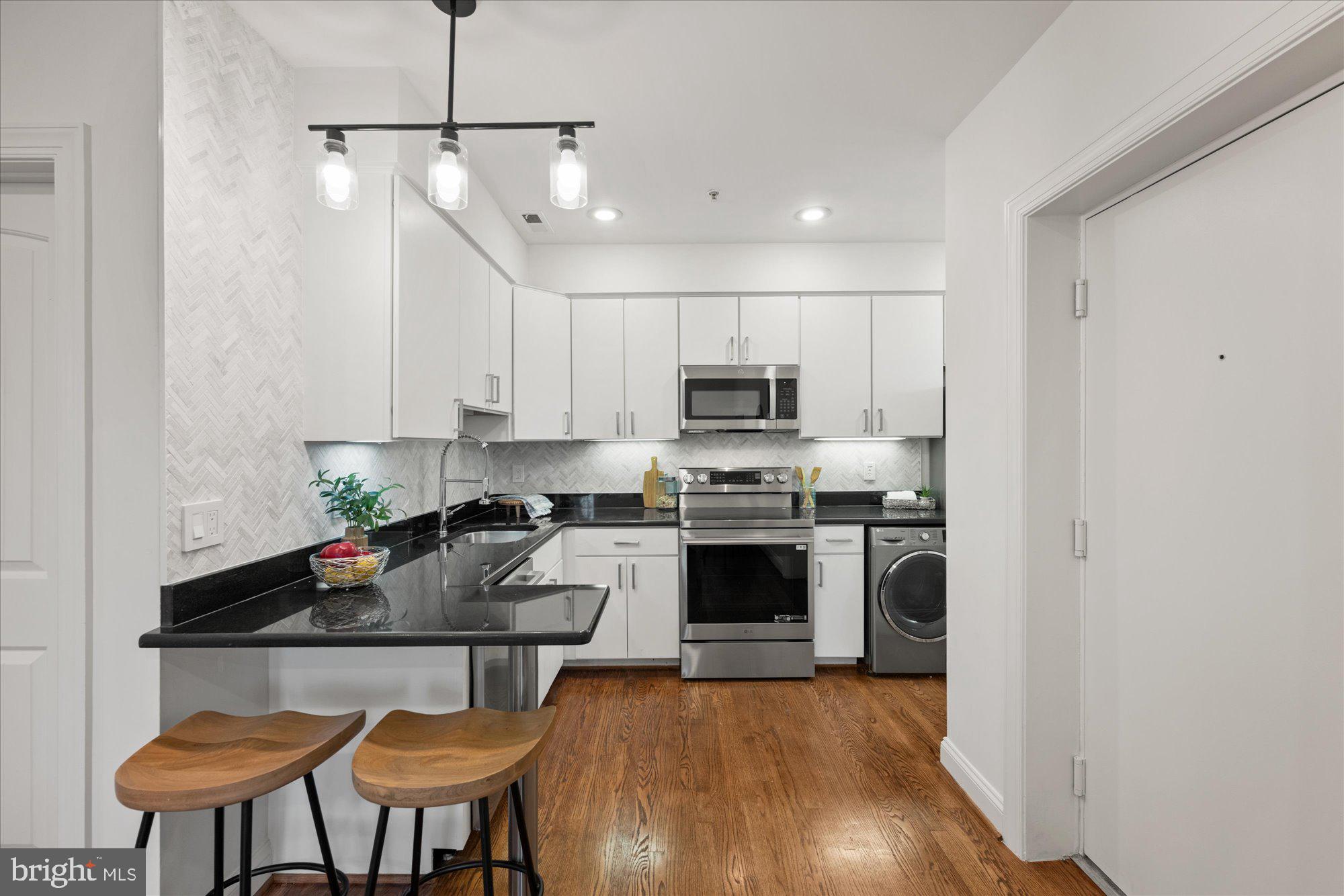 660 Morton Place Northeast, Unit 5 Washington, DC 20002 - Photo 9 of 21 a kitchen with stainless steel appliances granite countertop a stove a refrigerator a sink a stove with white cabinets and wooden floor