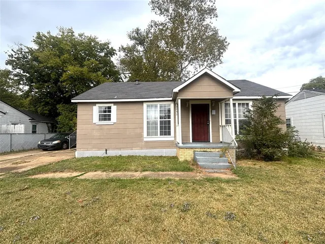 a front view of a house with a garden and yard