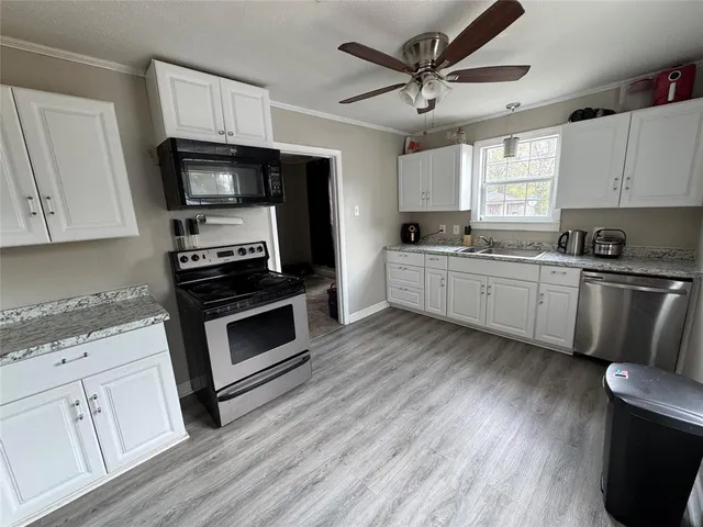 a kitchen with stainless steel appliances a stove a sink and a microwave