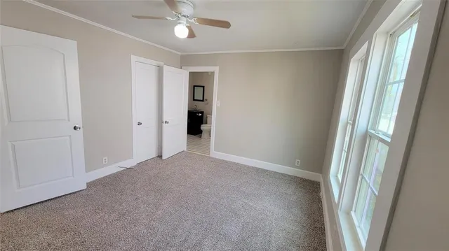 a view of a room with a ceiling fan and window