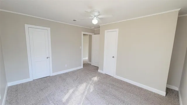 a view of an empty room with a ceiling fan