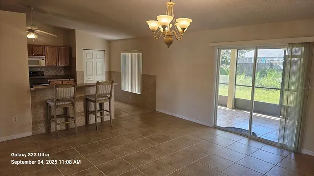 a view of a dining room with furniture a chandelier and window