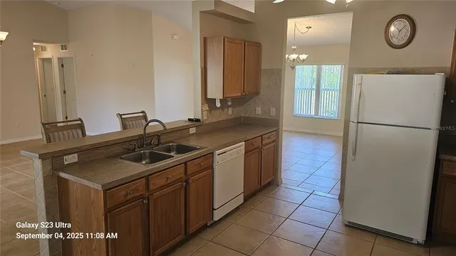 a kitchen with a sink refrigerator and cabinets