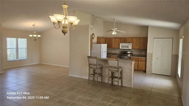 a kitchen with stainless steel appliances granite countertop a refrigerator and a stove top oven