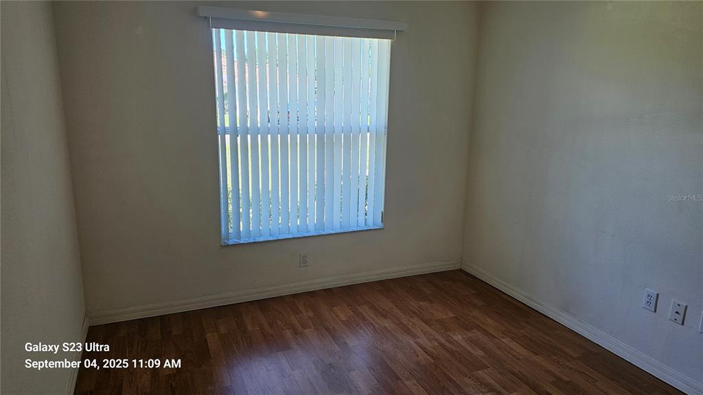 33 Fenwick Lane Palm Coast, FL 32137 - Photo 9 of 16 a view of an empty room with wooden floor and a window