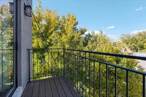 a view of a balcony with wooden floor and fence