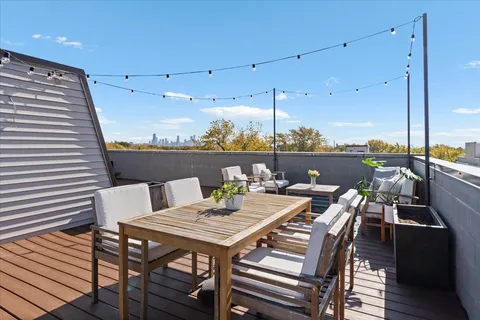 a view of a roof deck with table and chairs