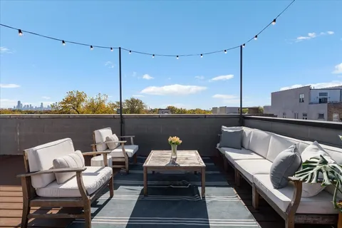 a view of a kitchen with kitchen island stainless steel appliances a stove and a chandelier