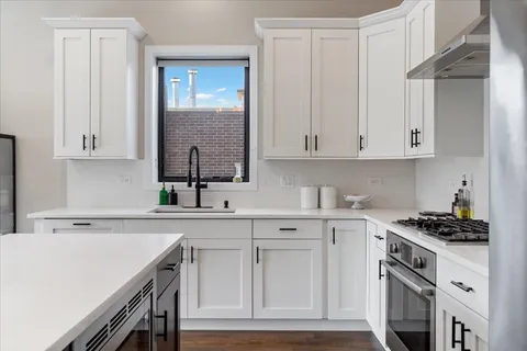 a kitchen with white cabinets and a stove