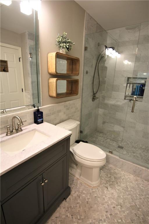 a bathroom with a sink a toilet and shower