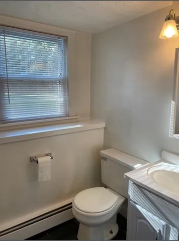 a white toilet sitting next to a window