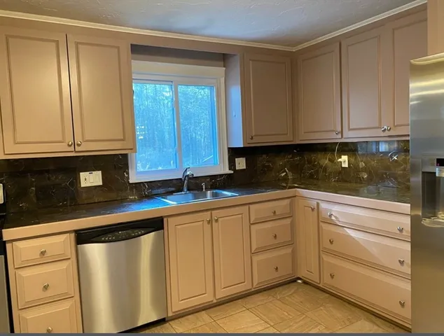 a kitchen with granite countertop white cabinets and stainless steel appliances