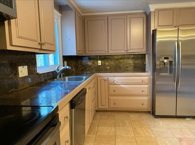 a kitchen with stainless steel appliances granite countertop a refrigerator and a stove