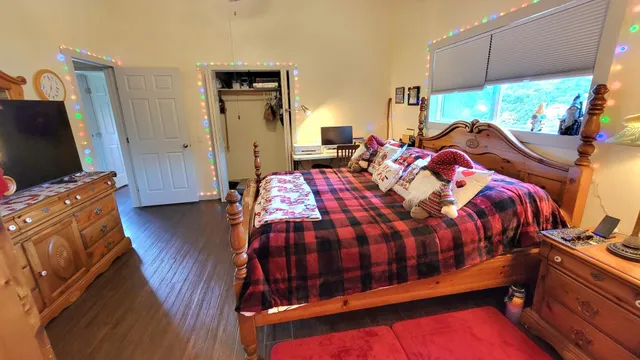 a bedroom with a bed a mirror and a window