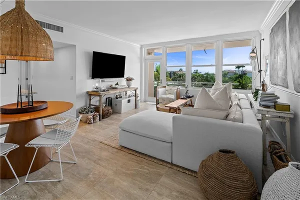 a living room with furniture a flat screen tv and a floor to ceiling window