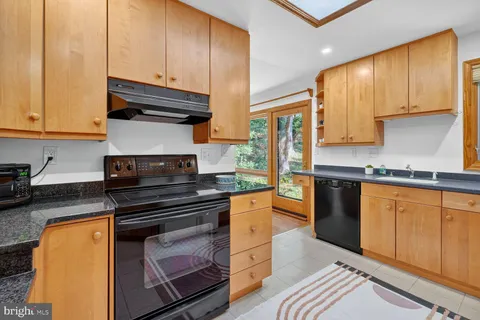 a kitchen with granite countertop wooden cabinets and stainless steel appliances