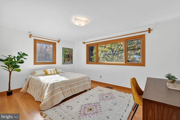a bedroom with a bed and a table with potted plant