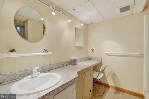 a bathroom with a granite countertop sink a mirror and a vanity
