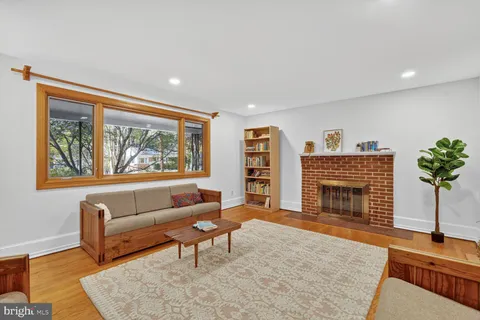 a living room with furniture a fireplace and a wooden floor