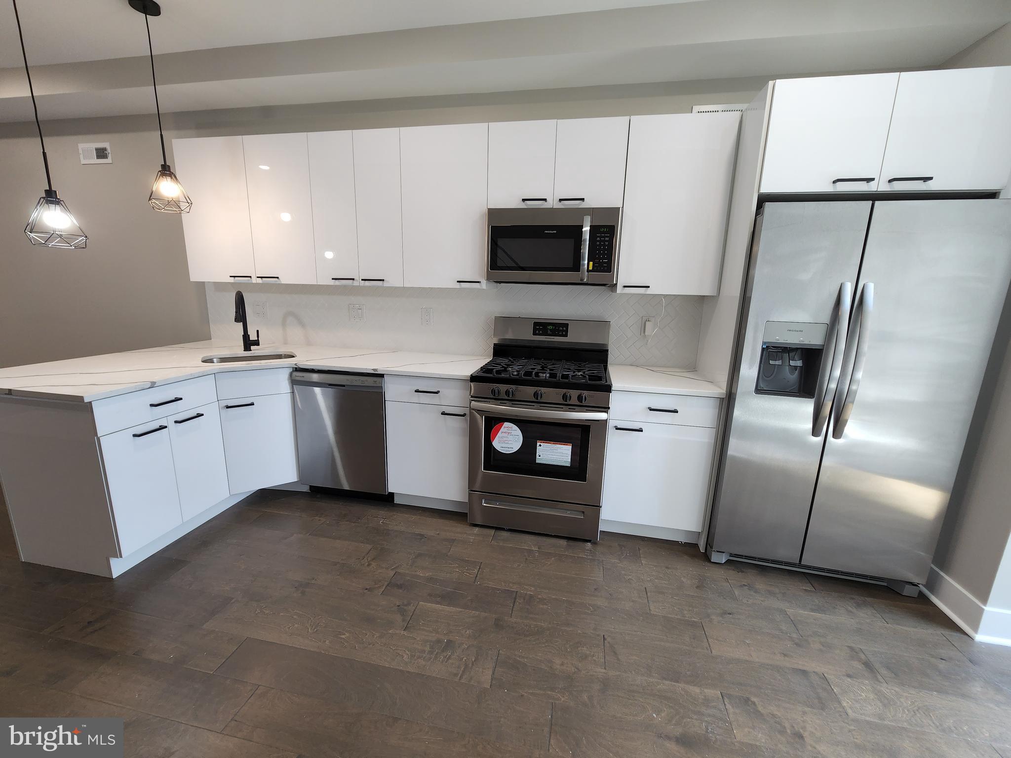 a kitchen with stainless steel appliances a refrigerator sink and microwave