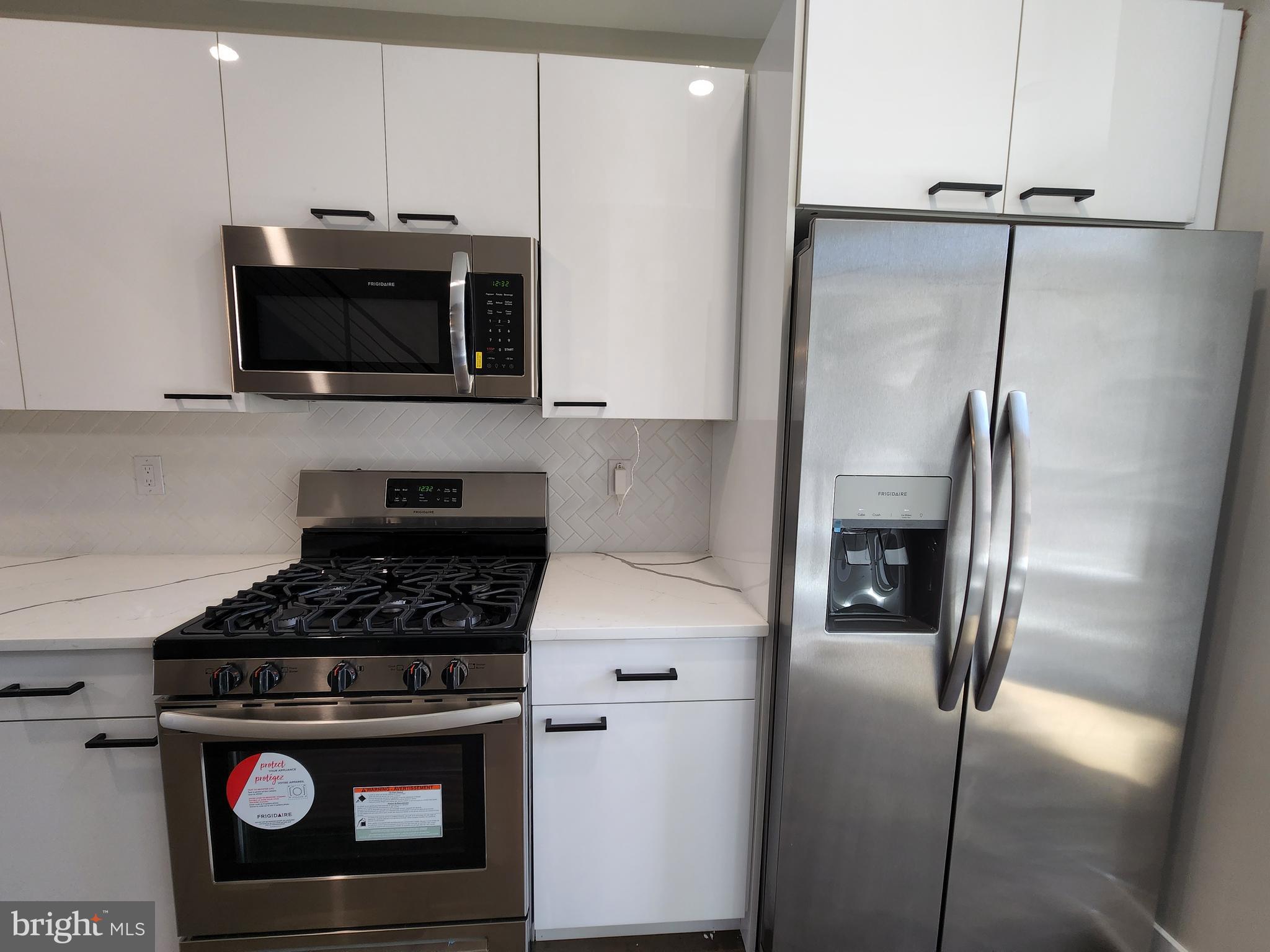 2449 Turner Street, Unit 2 Philadelphia, PA 19121 - Photo 3 of 24 a kitchen with stainless steel appliances a stove a microwave and a sink