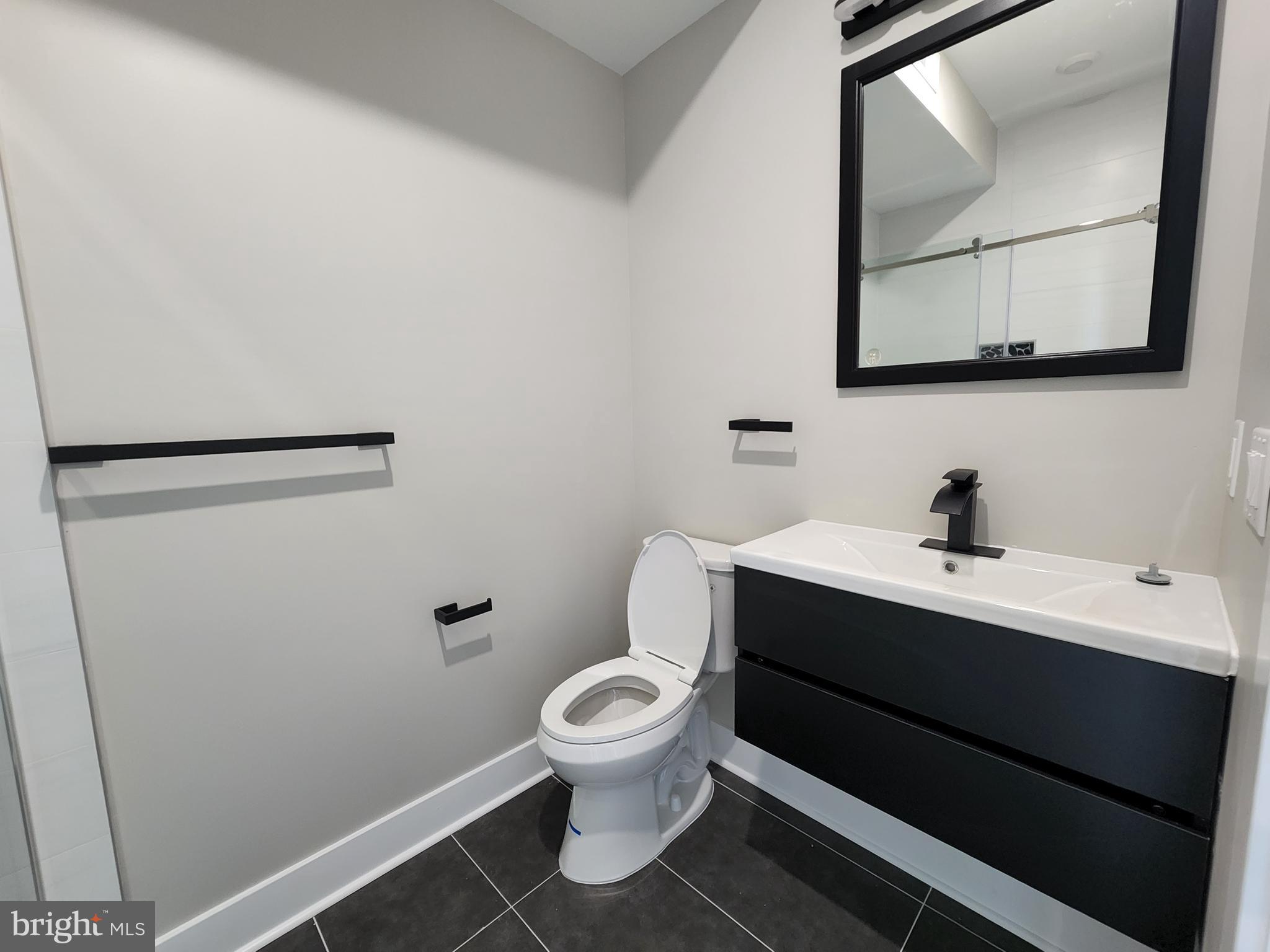 2449 Turner Street, Unit 2 Philadelphia, PA 19121 - Photo 10 of 24 a bathroom with a toilet sink and mirror