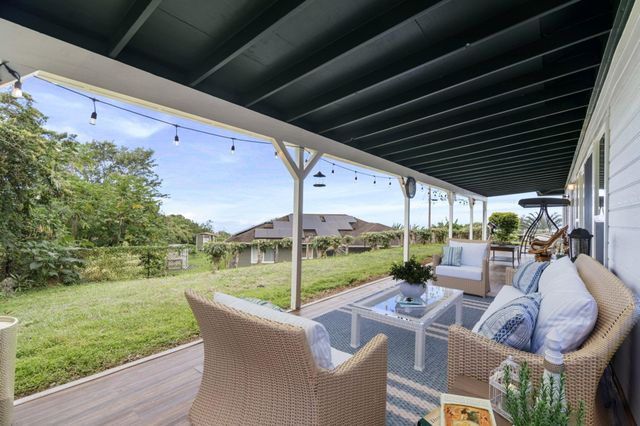 a view of a patio with couches chairs and a yard