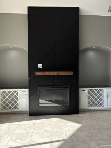 a view of an empty room with a fireplace and a window