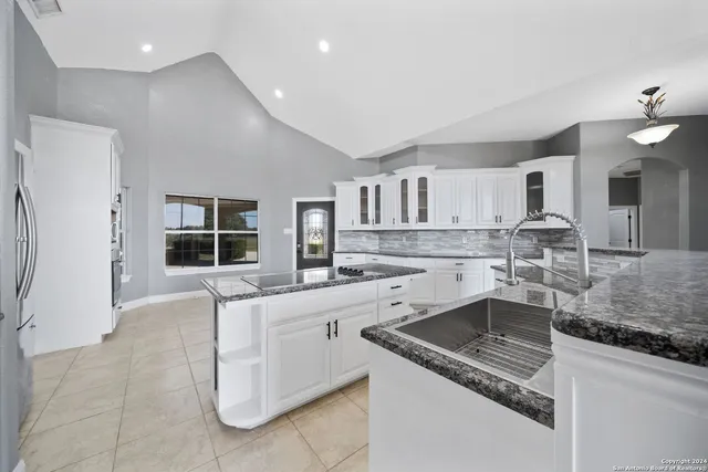 a large kitchen with stainless steel appliances kitchen island granite countertop a sink and dishwasher a stove with granite countertops