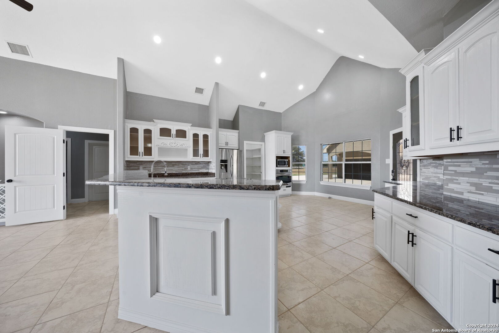 3022 Interstate 35 Natalia, TX 78059 - Photo 17 of 49 a large kitchen with stainless steel appliances kitchen island granite countertop a stove a sink a refrigerator and white cabinets